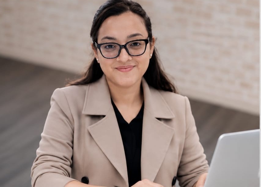 Pooja Negi working at her desk with a laptop